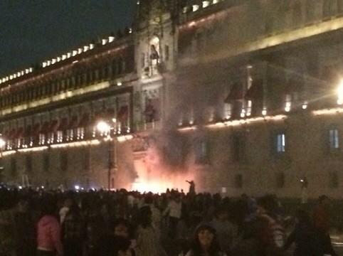 Demostrators set fire the door of the main entrance of te Mexican National Palace during a demostration in Mexico City on November 8, 2014, demanding justice from the Mexican goverment in the massacre of 43 missing students. (AFP Photo/Omar Torres)