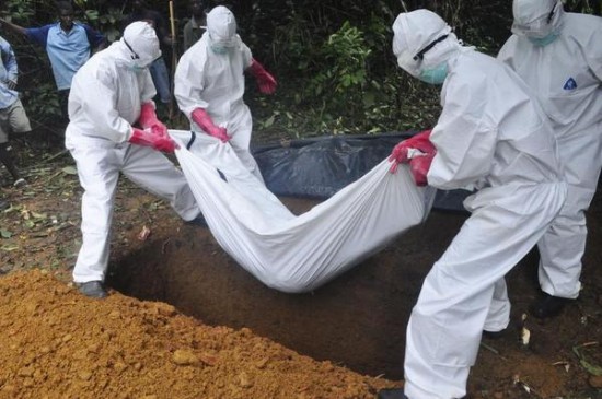 A burial team in protective gear bury the body of woman suspected to have died from the Ebola virus in Monrovia, Liberia. Saturday, Oct, 18, 2014. (Image source: AP/Abbas Dulleh)