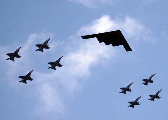 A U.S. B-2 Stealth bomber being escorted by U.S. Navy F/A - 18 Hornet fighter jets. PHOTO COURTESY: en.wikipedia.org