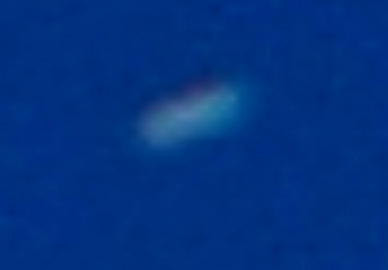 Cropped and enlarged photo of a UFO that was traveling in and out of clouds. Note what appears to be some kind of energy field surrounding the craft. Antelope Valley, Ca. Photo by Jim Kerr.